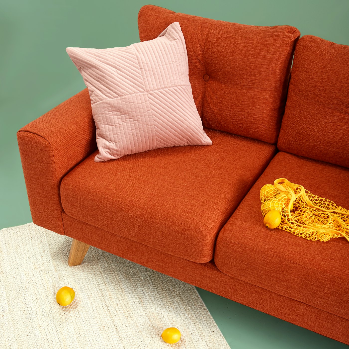 A Svant sofa styled with cushions and a woven rug