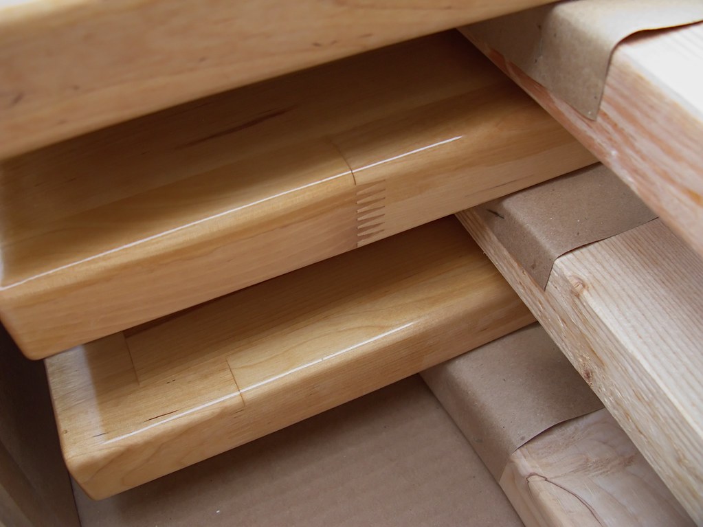Neatly stacked, finished solid-wood boards ready for the workshop